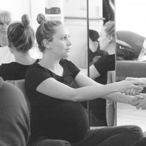 zwangere vrouw doet oefening met docent op de zwangerschapscursus